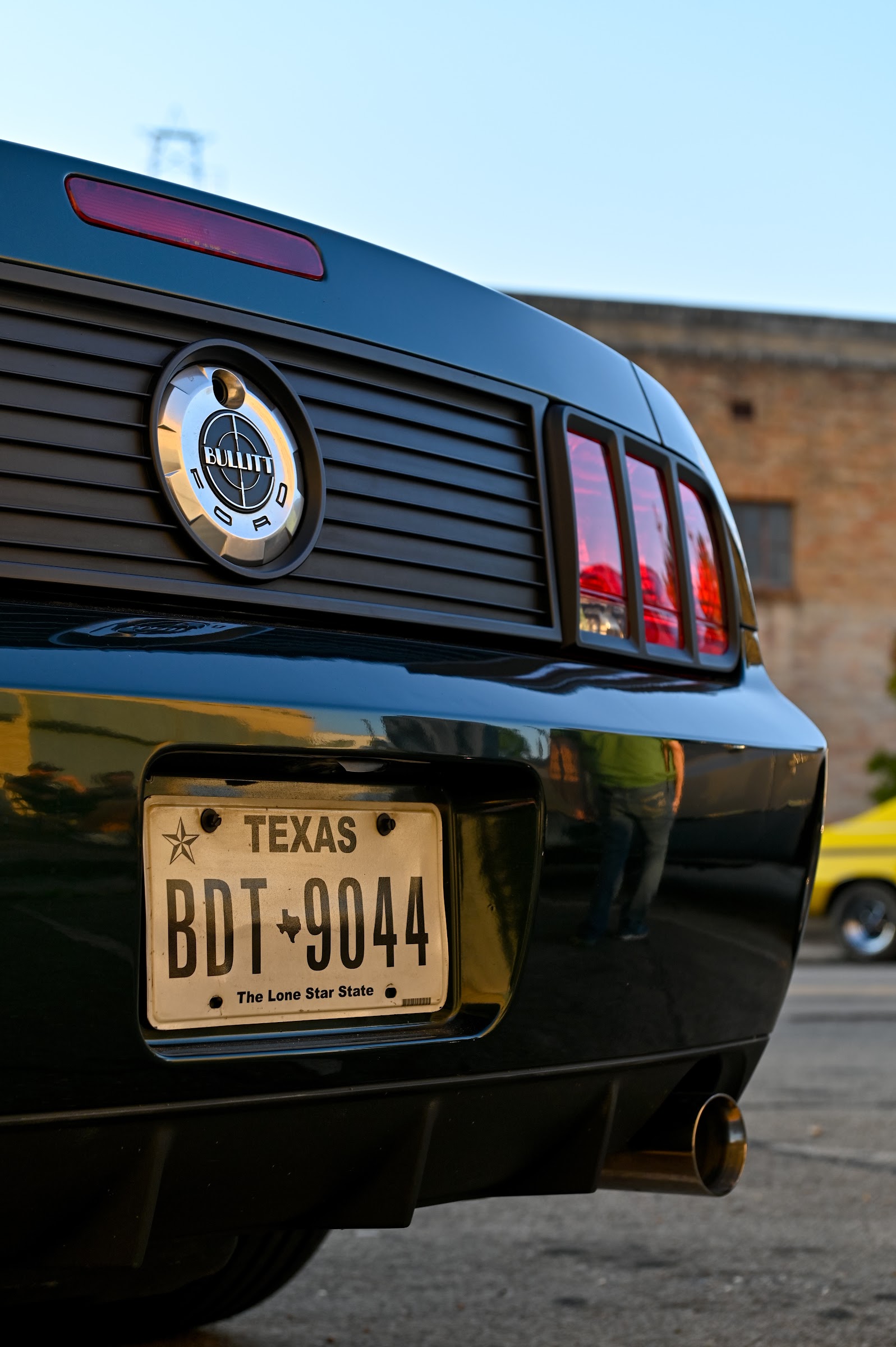 Rear view of a dark green Mustang with red taillights and a Texas plate — car photography in East Texas by Kaden Baker